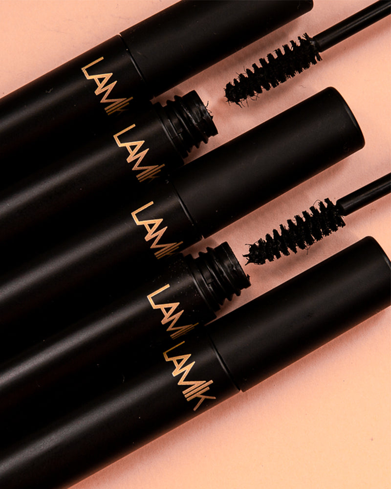 Black mascara tubes with wands and curly brush tips