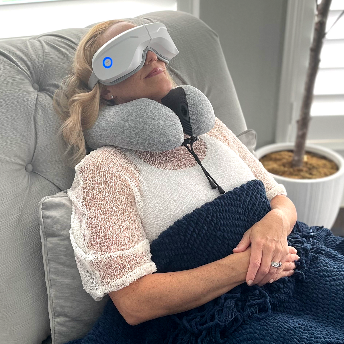 Memory foam travel pillow, gray neck cushion with black strap worn under eye mask