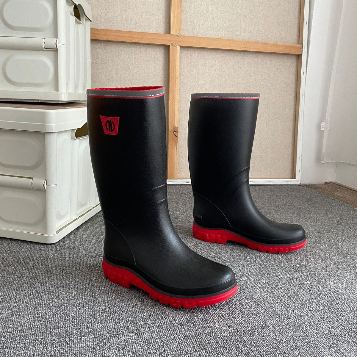 Knee-high rain boots in black rubber with red outsole and red edge trim