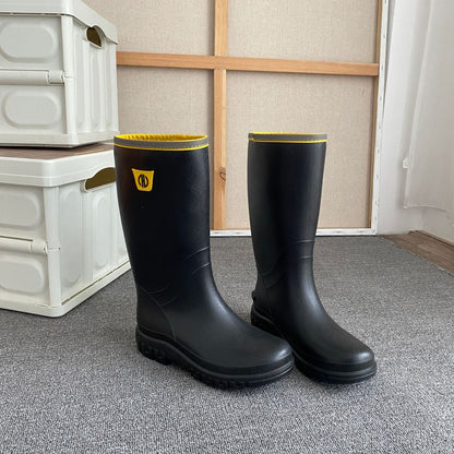Knee-high black rain boots with yellow top lining and yellow logo, pair view
