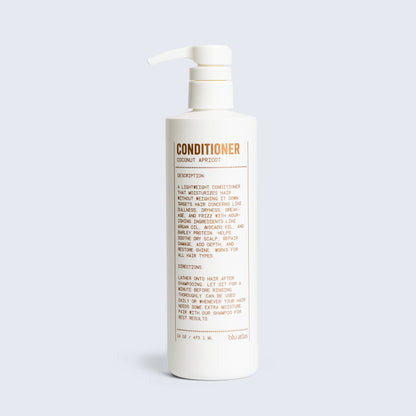 Conditioner bottle with pump, coconut apricot scent label visible