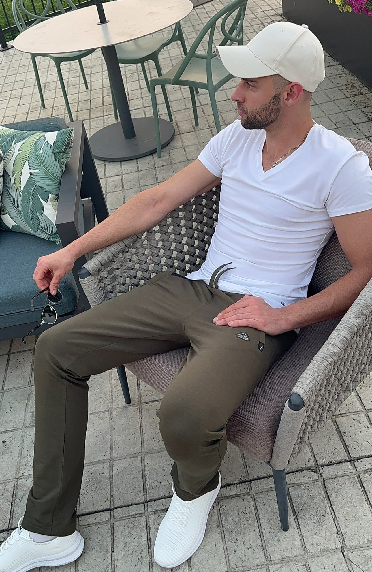 Khaki green straight athletic sweatpants with drawstring waist and side logo, sitting view