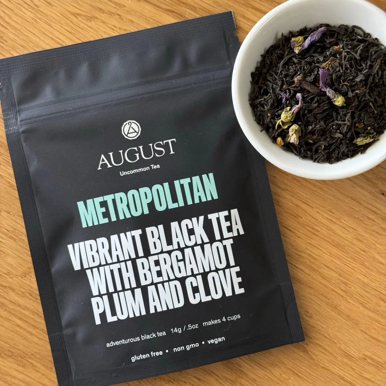 Metropolitan black tea pouch with a bowl of dark tea leaves beside it