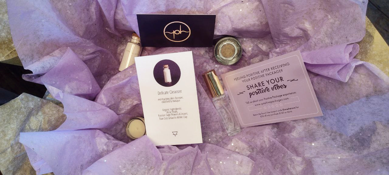 Skincare gift box contents with bottles, jars, and printed cards on tissue paper