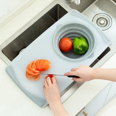Light blue plastic chopping board with integrated circular draining bowl