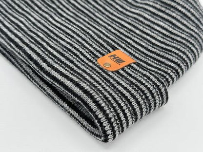 Rolled cuff of striped knit beanie in gray and black with orange logo patch