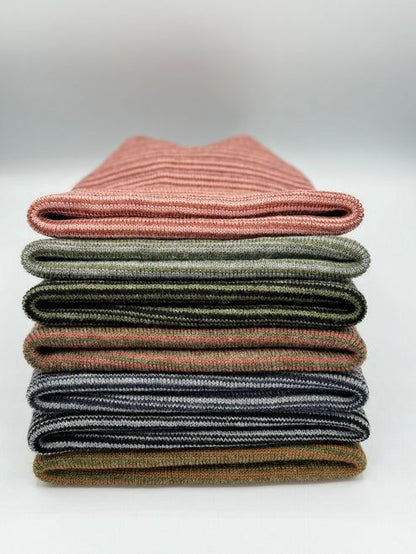 Stack of striped knit beanies with folded cuffs in multiple colors