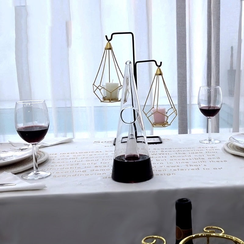 Transparent wine decanter on a dining table with two wine glasses and red wine