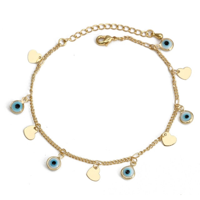 Charm bracelet with gold chain, blue evil-eye beads, and small heart charms