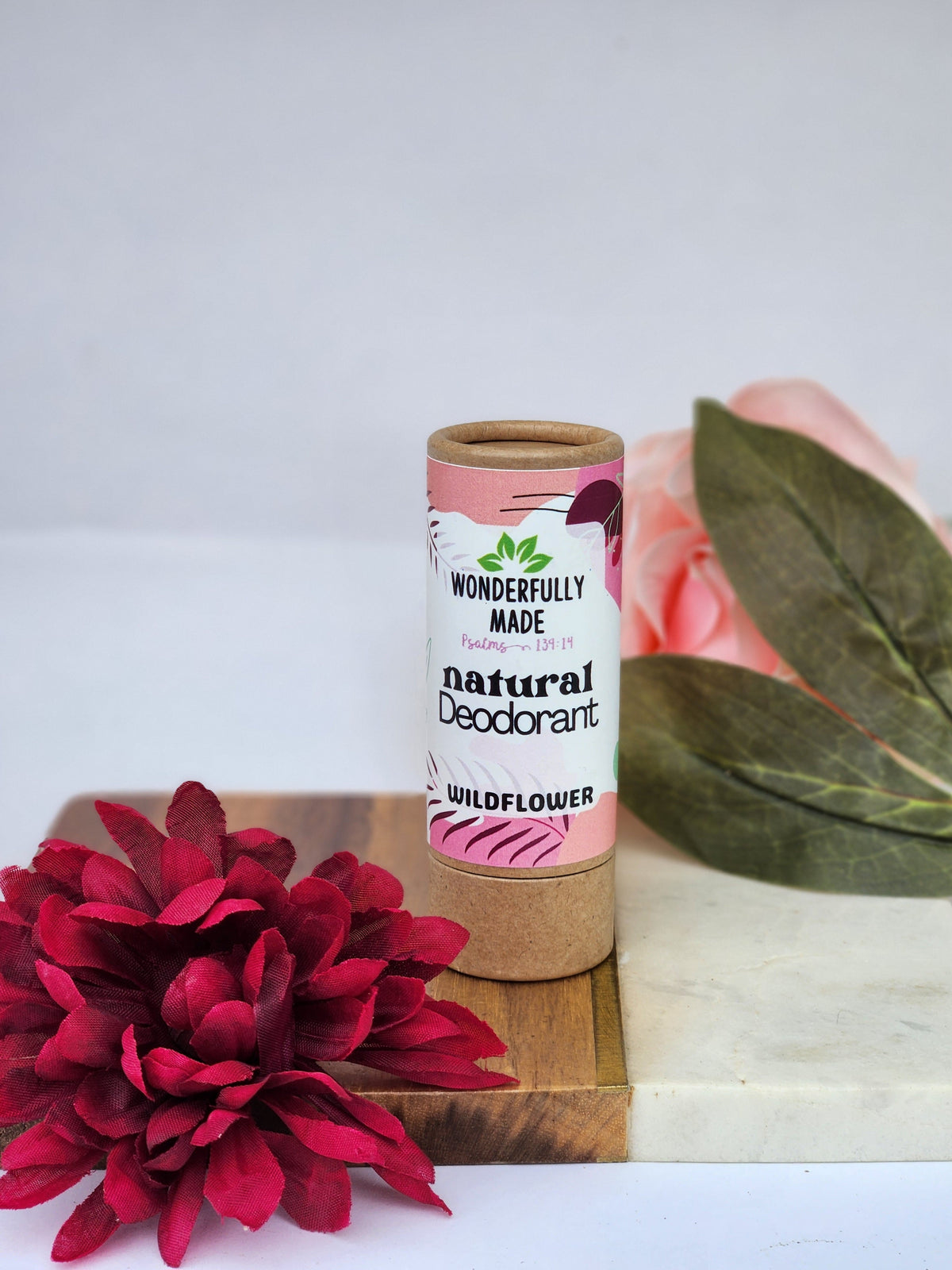 Natural deodorant stick in cardboard tube, Wildflower scent, pink label text.