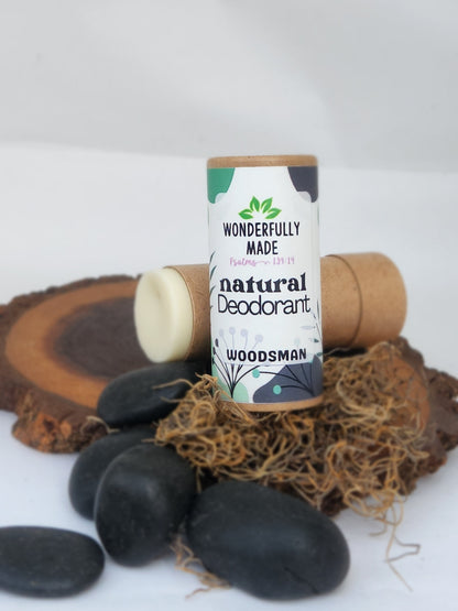Natural deodorant stick in cardboard tube, Woodsman scent, showing white deodorant.