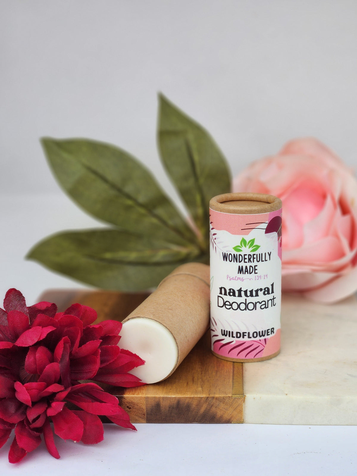 Natural deodorant stick in cardboard tube, Wildflower scent, pink label with floral art.