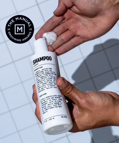 Natural shampoo bottle with back label, held in hands