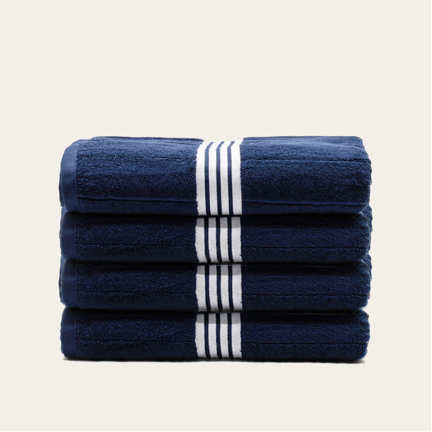 Stacked navy cotton towels with white striped bands