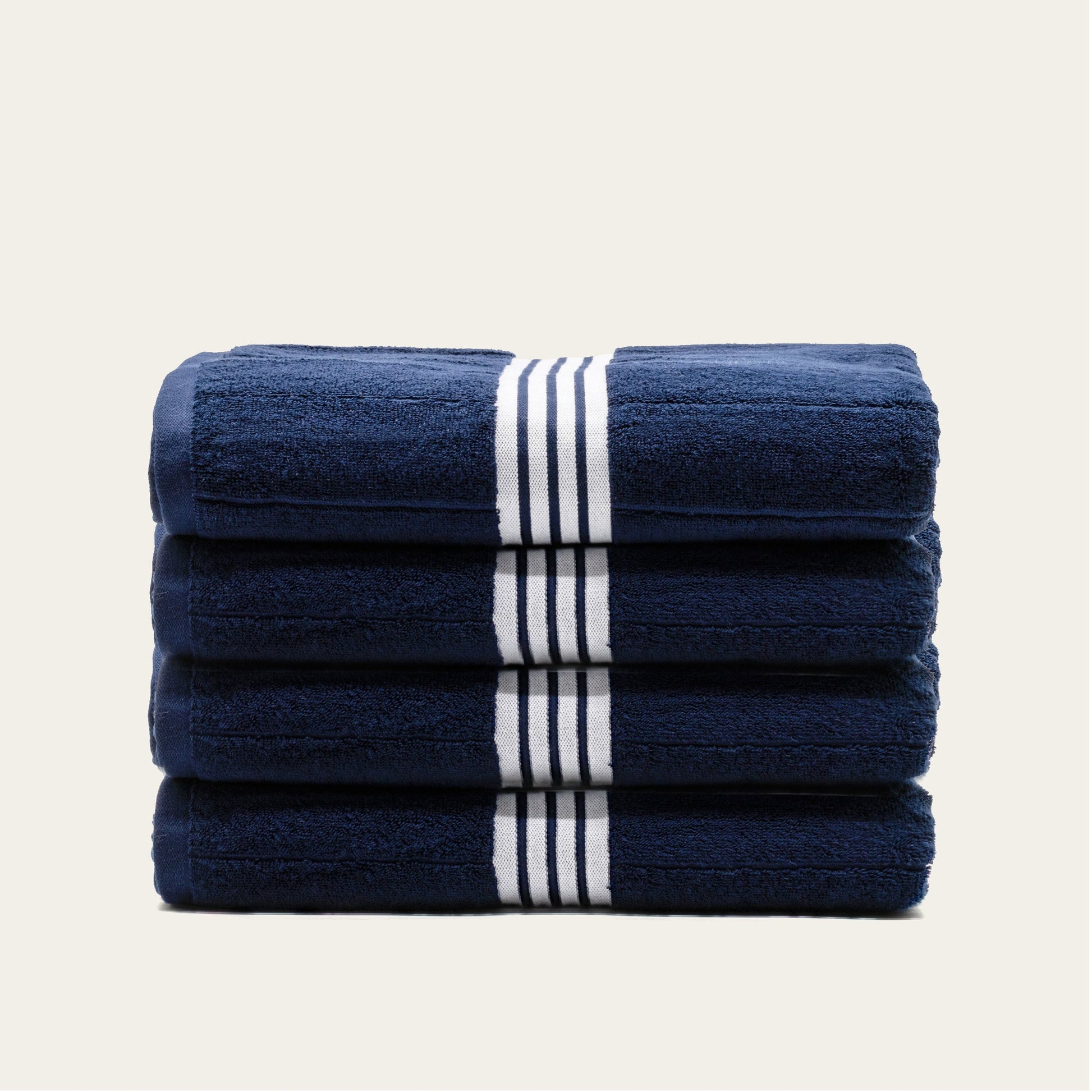 Stacked navy cotton towels with white striped bands
