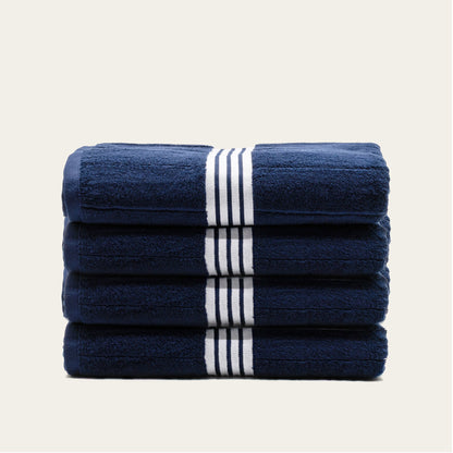 Stacked navy cotton towels with white striped bands