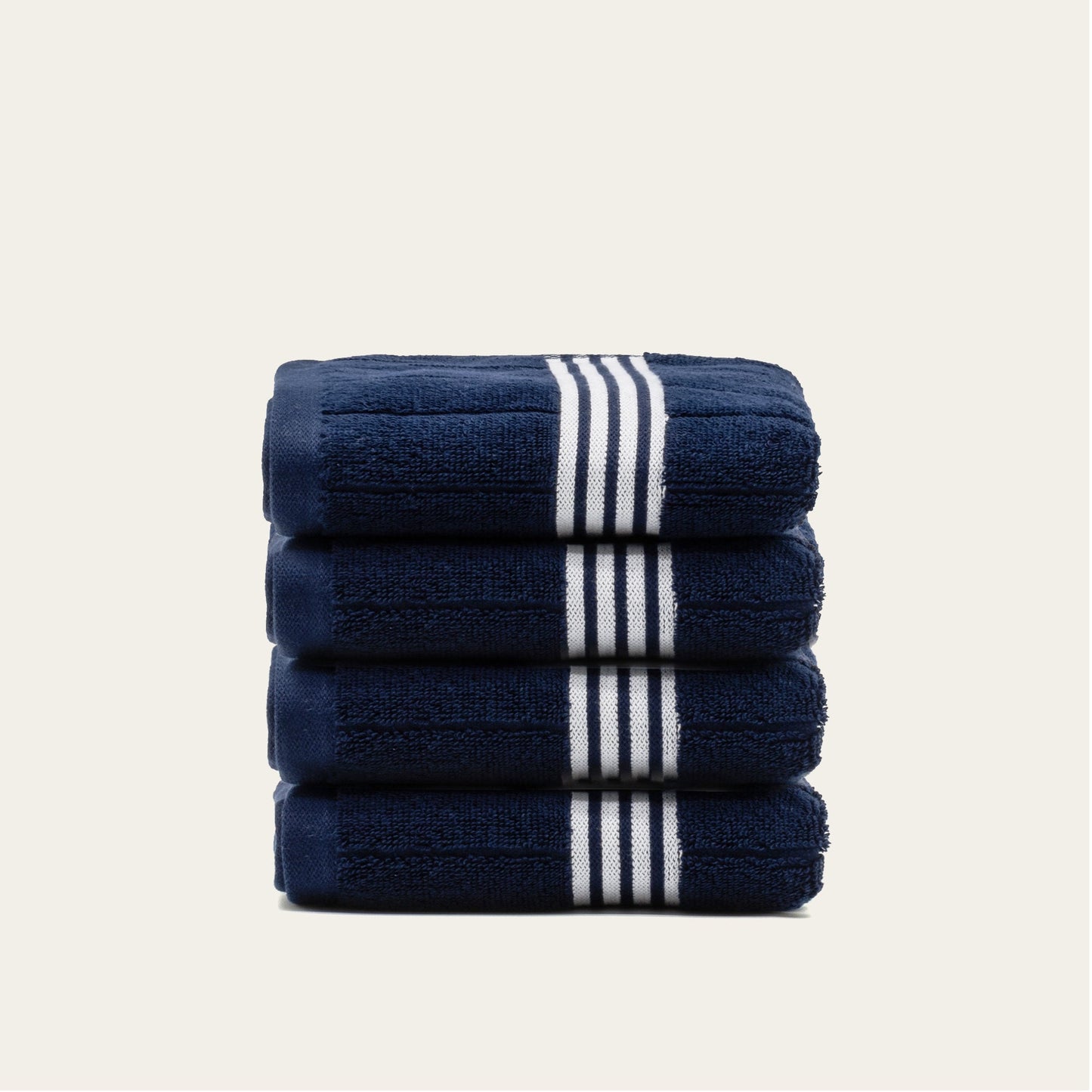 Stacked navy cotton towels with white striped bands, neatly folded