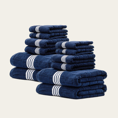 Multiple folded navy cotton towels with white striped bands, stacked