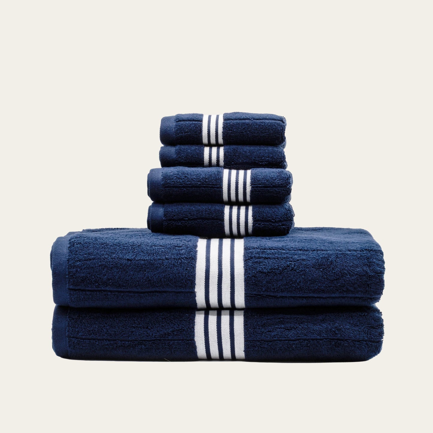Two-fold stack of navy cotton towels with white striped bands