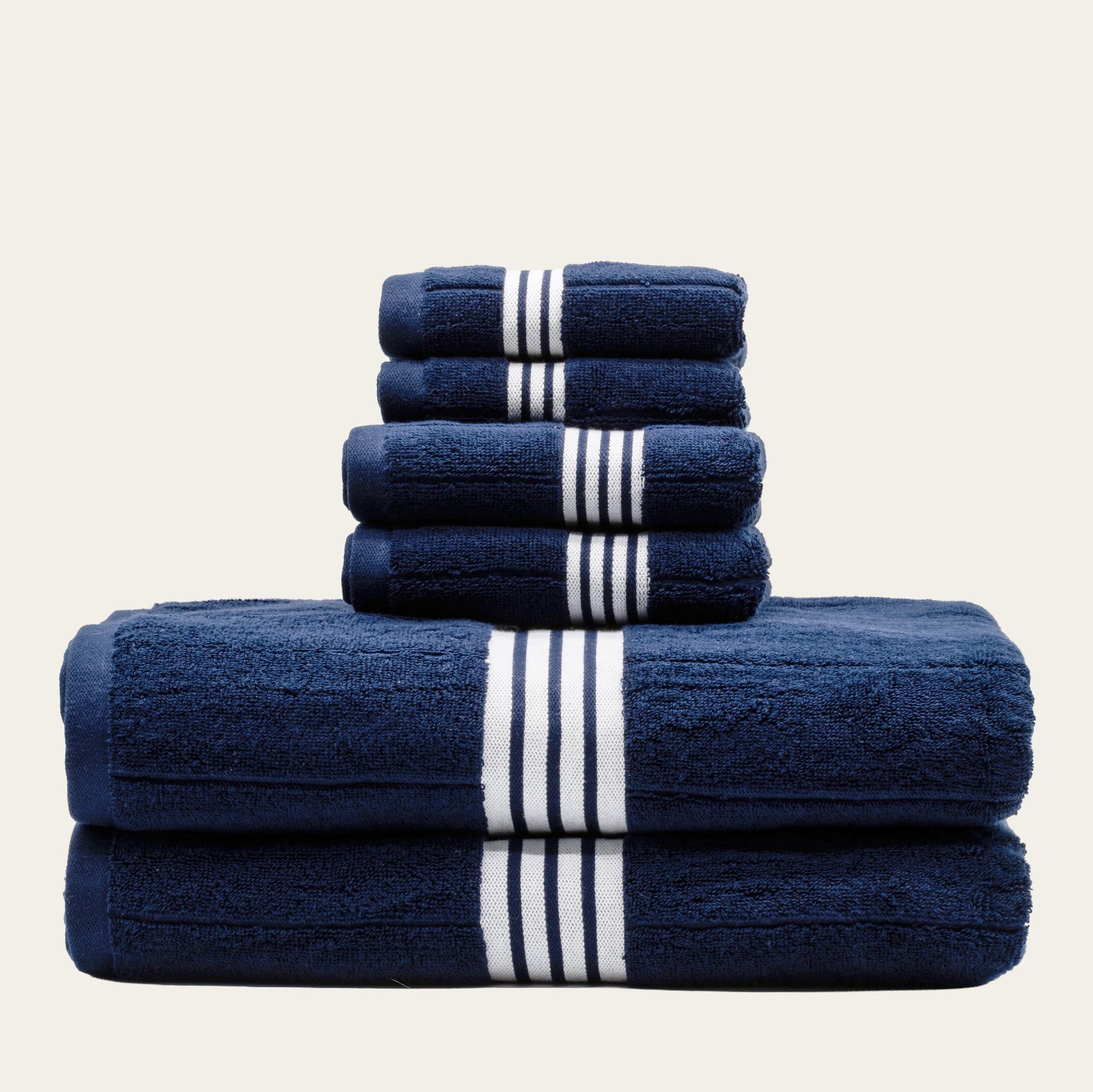 Navy cotton towels set with white striped bands, folded into a neatly stacked bundle.