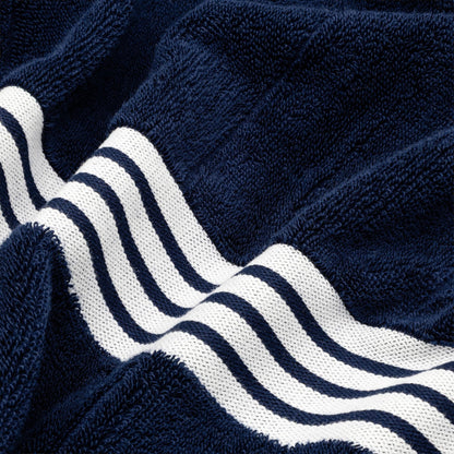Navy cotton towel with white triple-stripe band detail and textured terry loops.