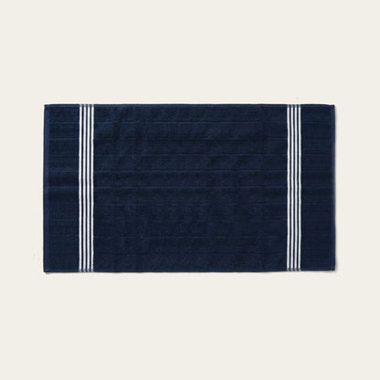 Navy cotton bath towel with white triple stripe bands on the sides.