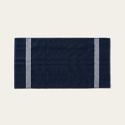 Navy cotton towel with white triple stripe bands along the edges, folded flat.