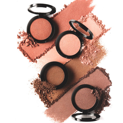 Pressed shimmer powder compacts in round cases with scattered powder swatches.