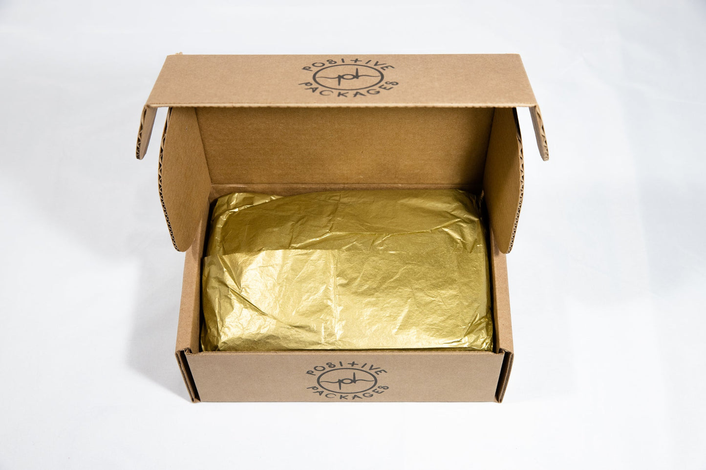 Open kraft gift box with gold tissue lining inside