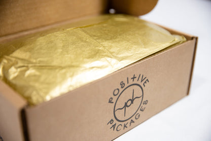 Close-up of gold tissue inside kraft box with logo printing on side