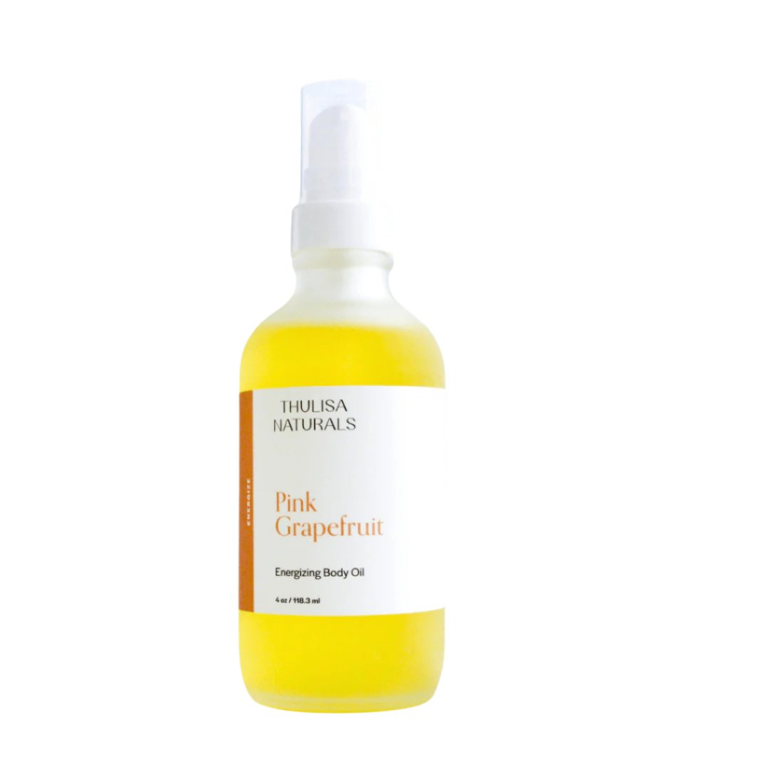 Pink grapefruit body oil bottle with pump, yellow liquid, white cap
