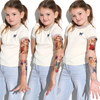 Child wearing temporary tattoo sleeve on forearm with colorful floral and butterfly art