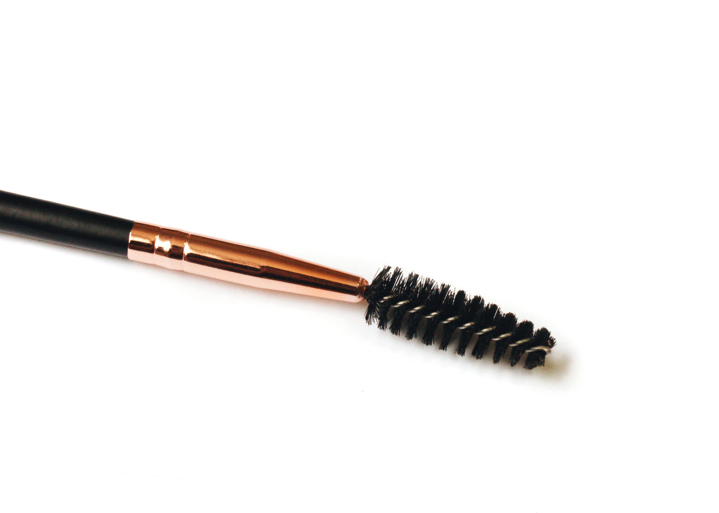 Spoolie end of eyebrow duo brush with black bristles and copper ferrule on handle.
