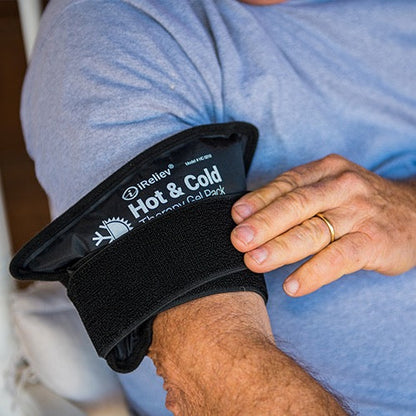 Hot and cold therapy gel pack with strap, close-up on arm holding it in place