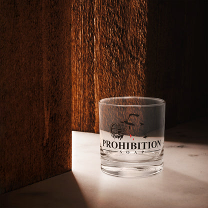 Clear glass tumbler with black logo graphic and orange band along the bottom