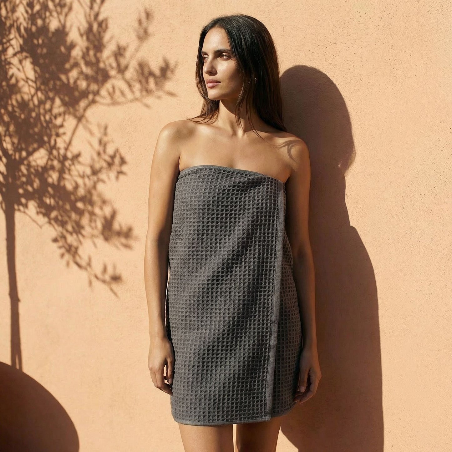 Charcoal waffle cotton towel, draped wrap style over body with textured grid weave