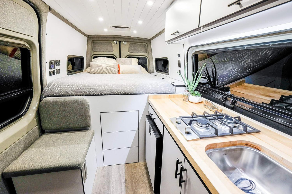 Built-in 2-burner gas cooktop in a van kitchenette with wood-look counter and drawers