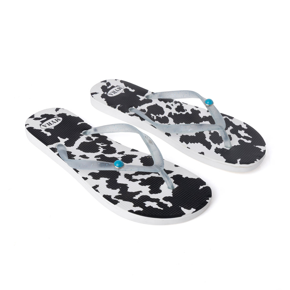 Pair of cowhide slippers with black-and-white cow print straps, light blue thong