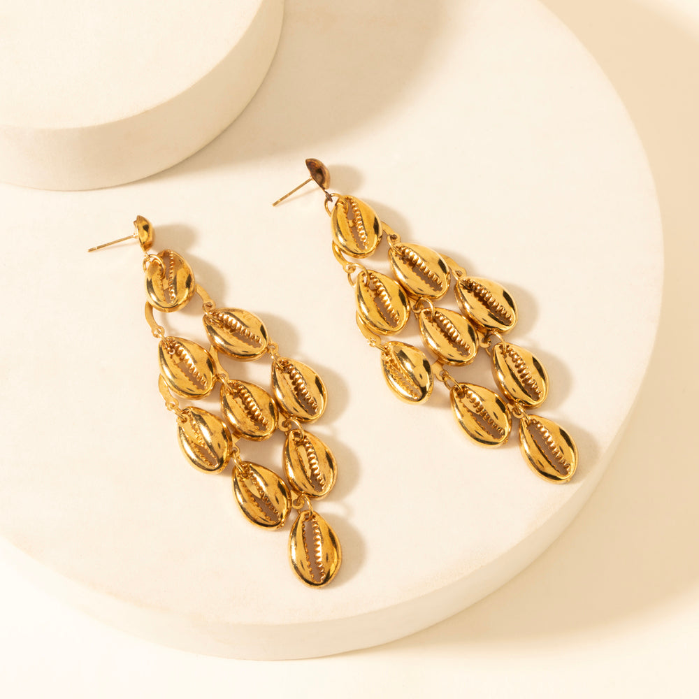 Gold shell-style drop earrings with multiple stacked leaf-like charms
