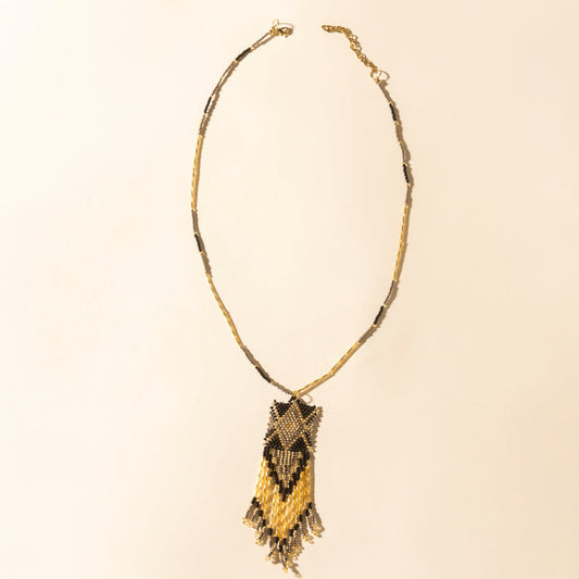 Beaded necklace with dark brown and gold crescent pendant and fringe