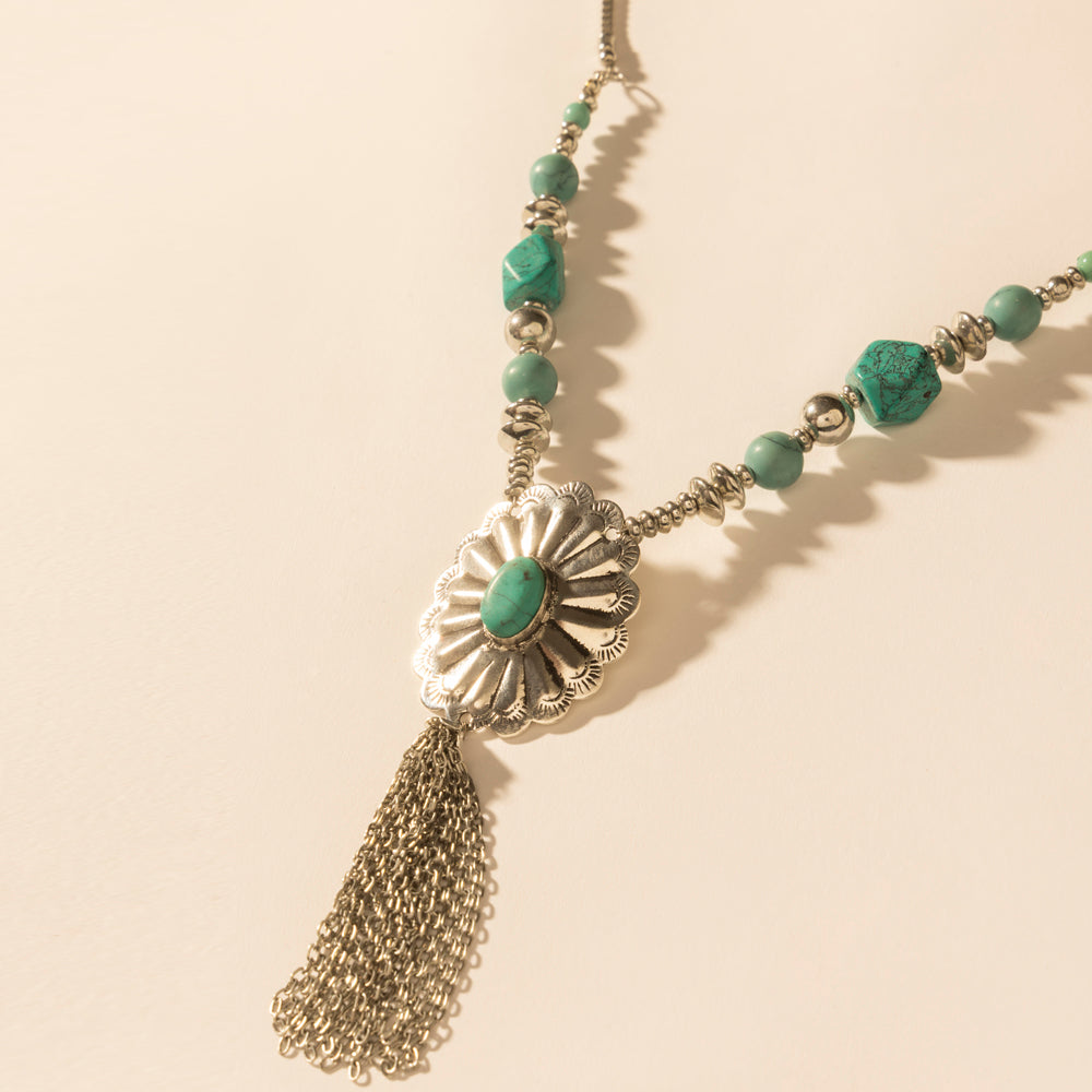Sunburst pendant necklace with turquoise bead stations and long gold-tone tassel