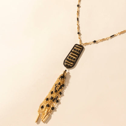 Burnished tan pendant necklace with black-gold rectangle charm and gold tassel drop