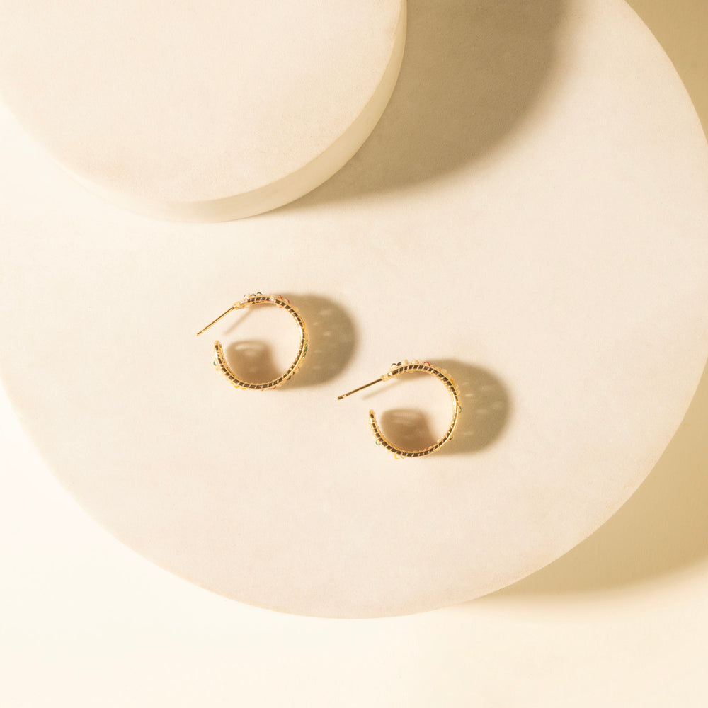 Gold-tone hoop earrings with ivory teardrop centers and subtle cross accents