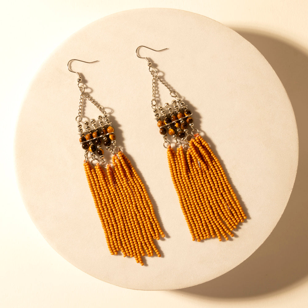 Beaded fringe earrings with silver hooks, orange bead tassels, and dark bead cluster tops.