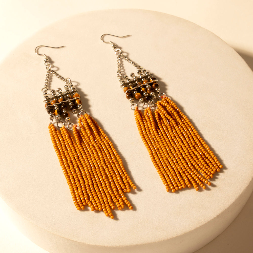 Beaded long drop earrings with silver hooks, orange tassel fringe, and dark top beadwork.