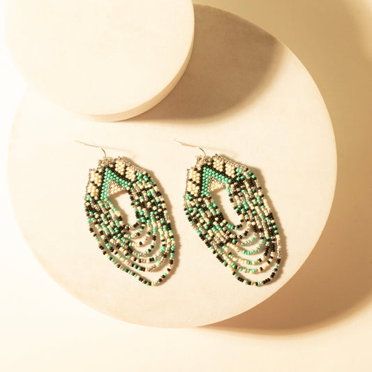Beaded turquoise teardrop dangle earrings with gold-tone wire and fringe detail