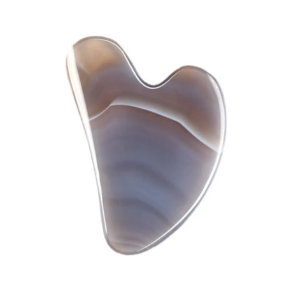 Facial gua sha stone massager, dark marbled purple-brown surface with curved edge