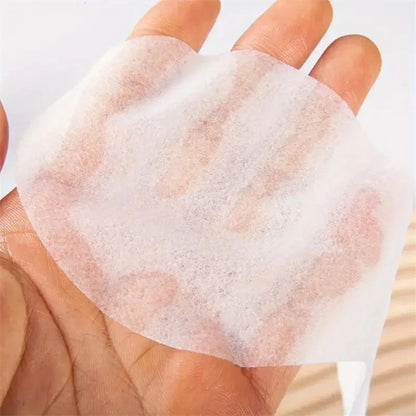 Translucent disposable eye pad sheet held in a hand, sheer texture