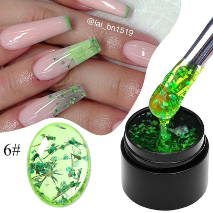 Flower fairy gel nail polish on pale pink nails with green dried flower flakes; jar shown