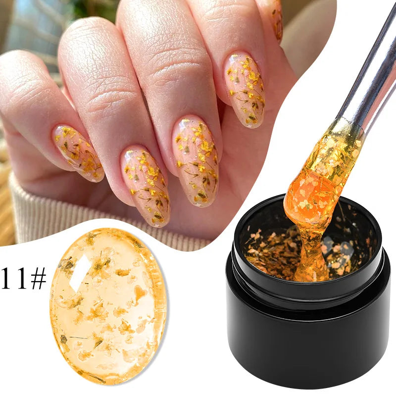 Flower fairy gel nail polish on nude nails with gold-orange dried flower flakes; jar shown
